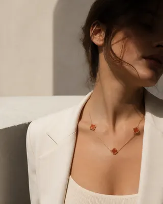 گردنبند طلای زنانه سه گل قرمز ون کلیف روی گردن، با طراحی دو لایه